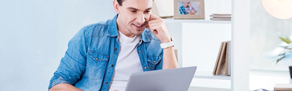 Man looking at laptop in a home setting