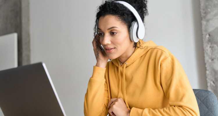 Woman with headphones watching laptop