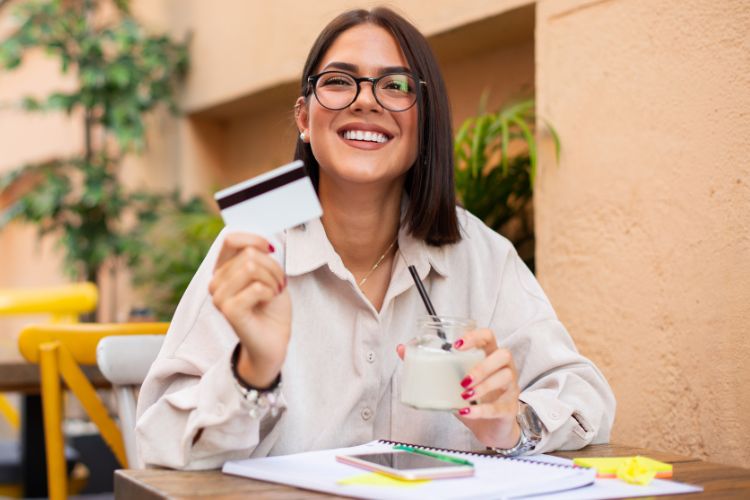 Woman at outdoor restaurant holding credit card