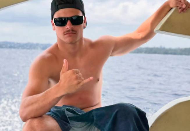 Kolby Aipa on a boat flashing hang ten sign
