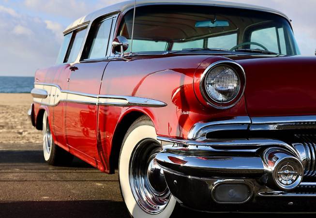 A red classic car parked at beach