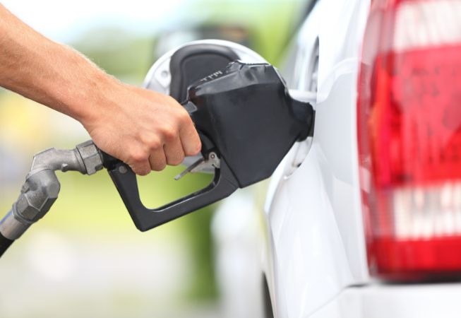 Hand pumping gas into car