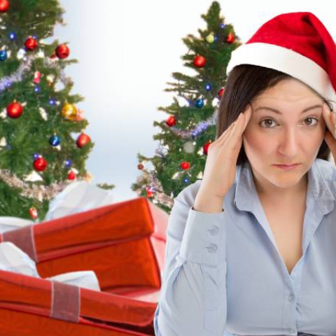 Woman at laptop wearing Santa looking stressed
