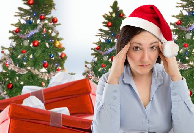 Woman at laptop wearing Santa looking stressed