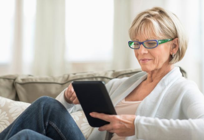 Woman on couch using tablet